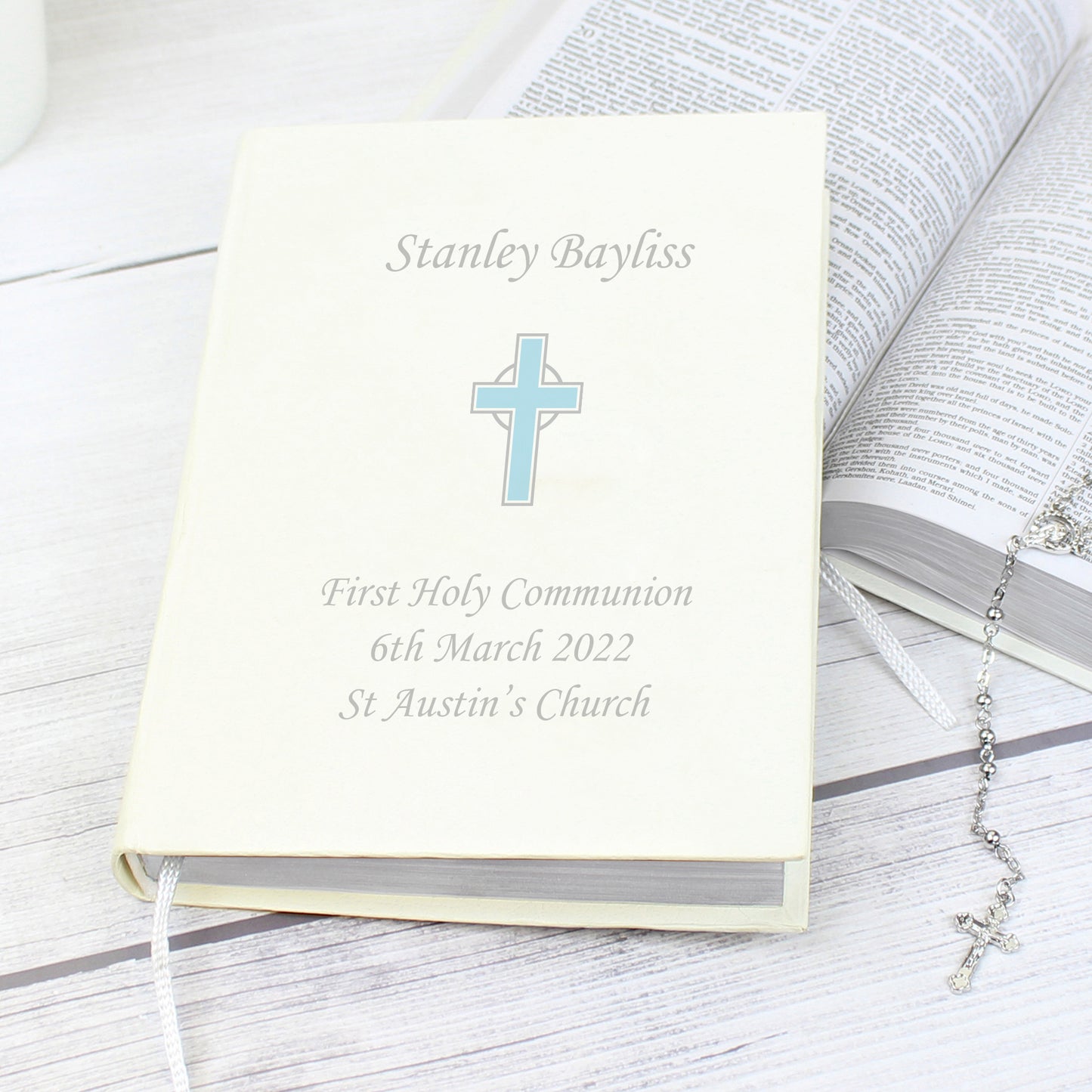 White faux leather King James Bible with blue cross and up to four lines of personalised text. Bible has one ribbon bookmark.