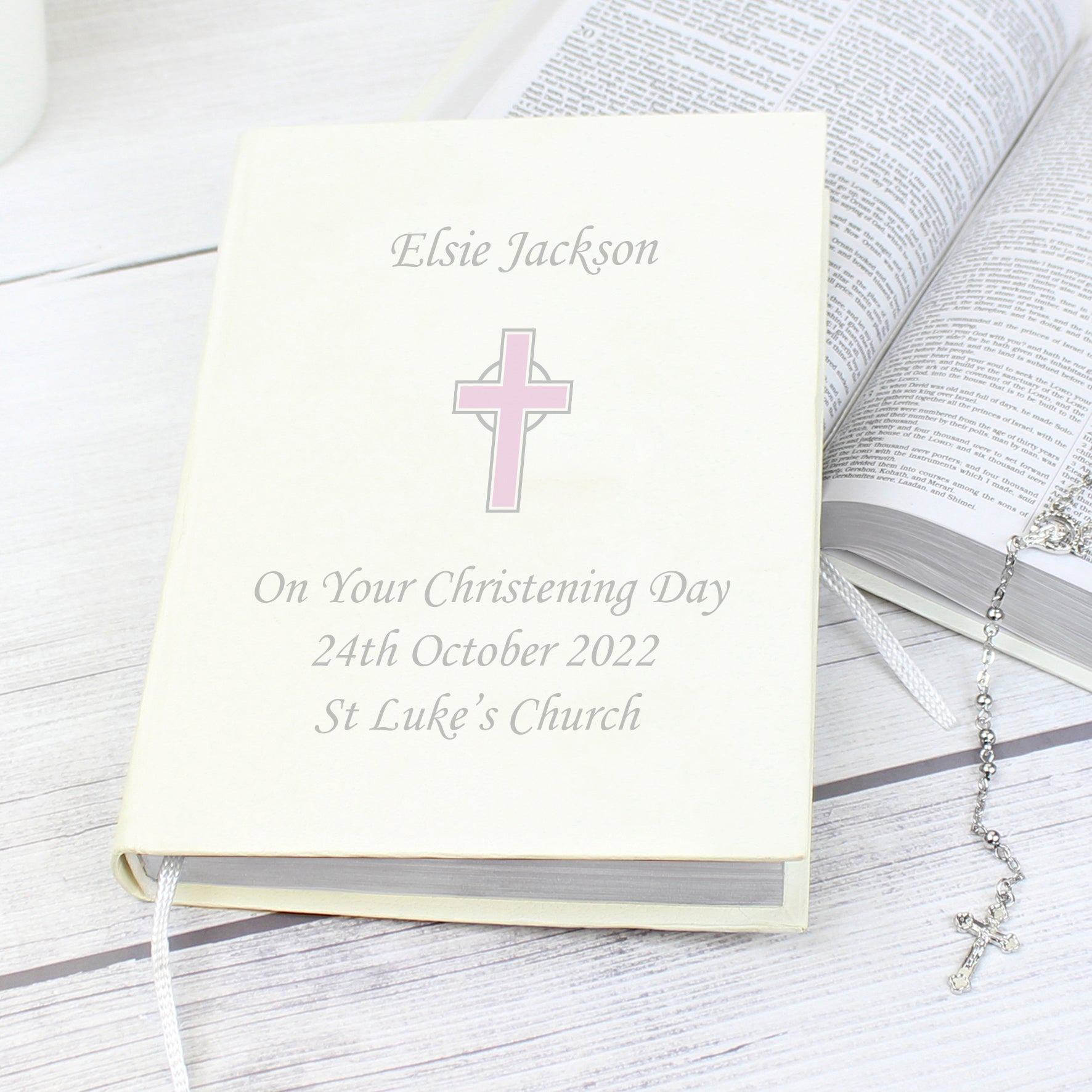 White faux leather King James Bible with pink cross and up to four lines of personalised text. Bible has one ribbon bookmark.