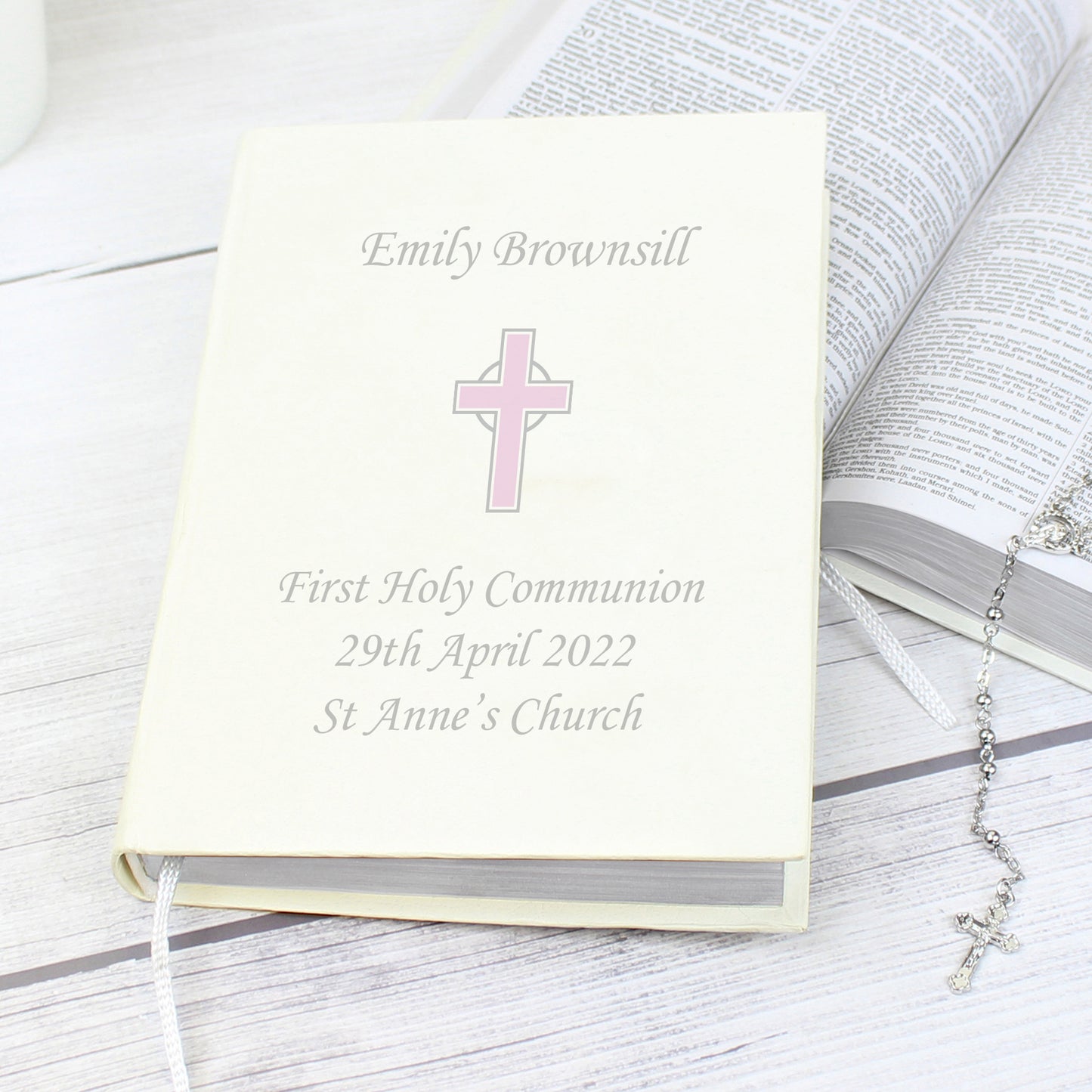 White faux leather King James Bible with pink cross and up to four lines of personalised text. Bible has one ribbon bookmark.