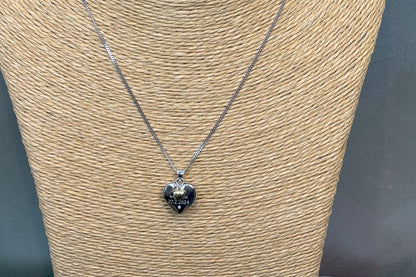 sterling silver heart shaped locket with engraved message and tiny gold heart, close up view