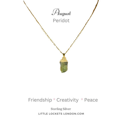 Peridot raw crystal gem with sterling silver gold plated tip suspended on sterling silver gold plated chain. Mounted on card with August birthday month, the name of the gem and the three qualities - friendship, creativity, peace. 