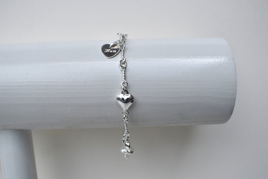 Sterling silver puffed heart and twist link bracelet showing a 10mm sterling silver heart engraved with the word "Mum". 