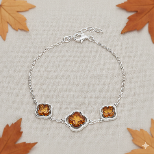 Amber trio bracelet consisting of three amber stones in a clover surround on a sterling silver bracelet. 