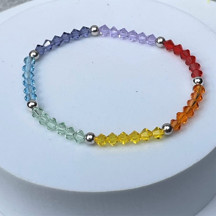 Multicolour rainbow crystal stacking bracelet made up of 4mm high quality crystals interspersed with a silver plated bead. Elasticated for comfort.