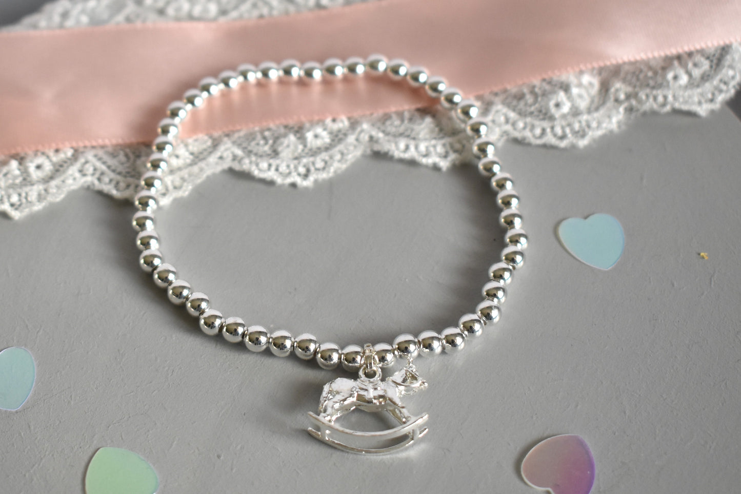 sterling silver beaded bracelet, threaded on strong elastic with a sterling silver rocking horse charm