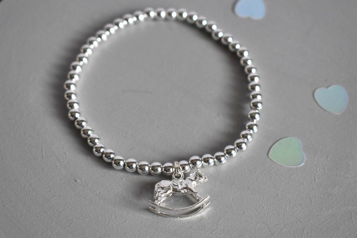 Silver bracelet consisting of 4mm sterling silver beads with a sterling silver rocking horse charm