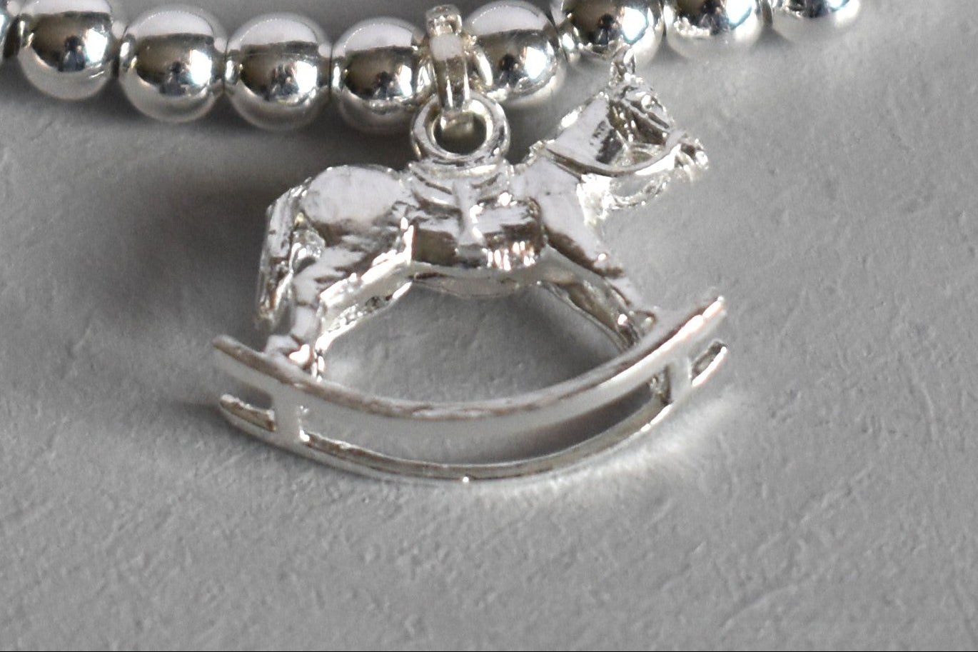 Close up of sterling silver rocking horse charm