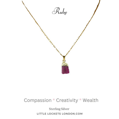 The ruby raw crystal pendant with gold plated sterling silver tip and suspended from a sterling silver gold plated chain. The pendant is mounted on card with the gem's name and three of its properties - compassion, creativity and wealth.