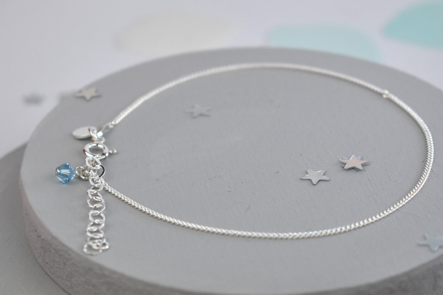 Sterling silver anklet shown with blue crystal and extender chain.