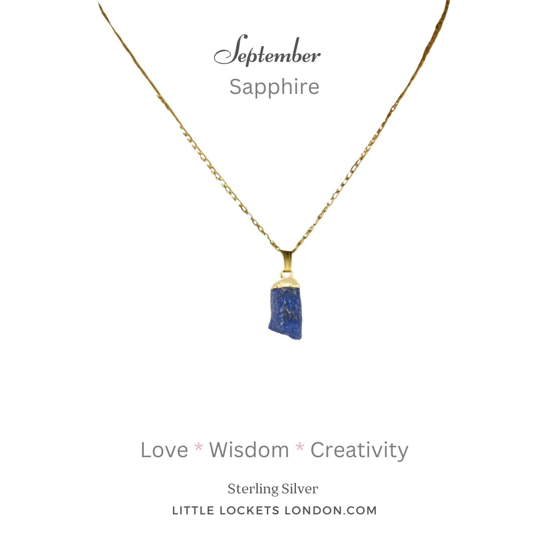 Sapphire raw crystal pendant with sterling silver gold plated tip suspended from a gold plated sterling silver chain. Mounted on card with the birth month of September and the gem's name plus three of its properties - love, wisdom and creativity