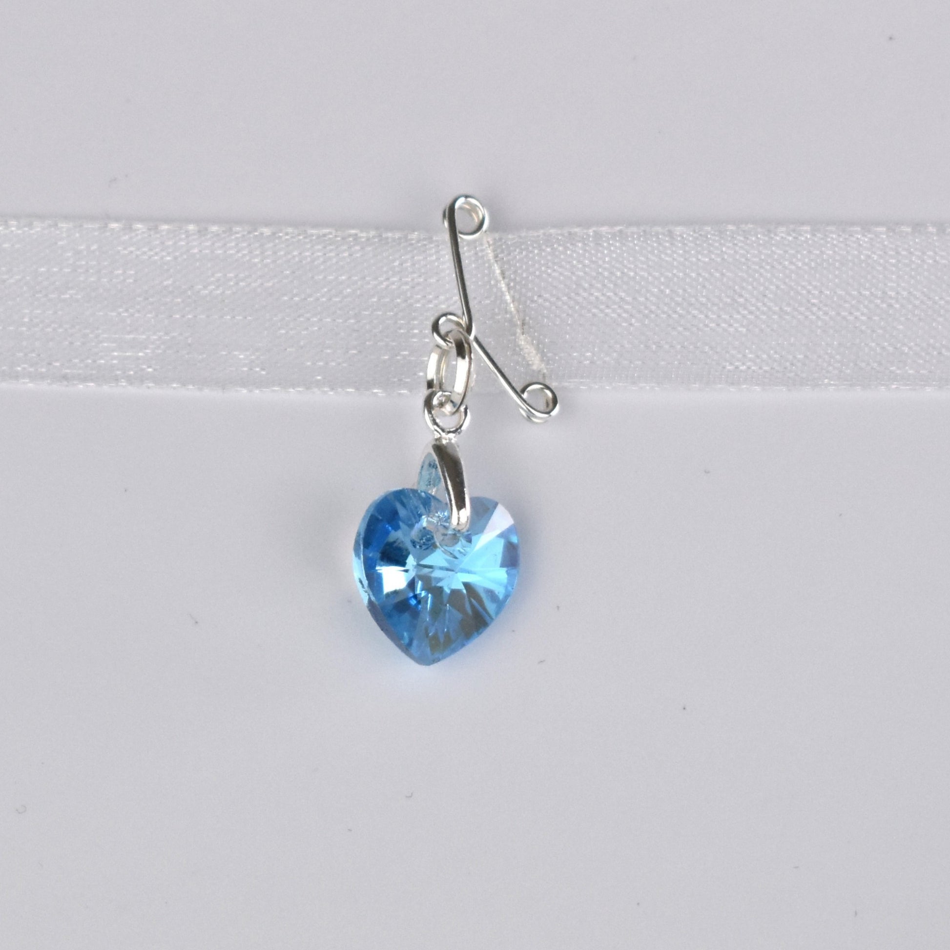 Blue crystal heart suspended from a sterling silver bail and a tiney sterling silver pin. Pin it in a secret place on your gown or add  it to your bouquet charm with the ribbon supplied.
