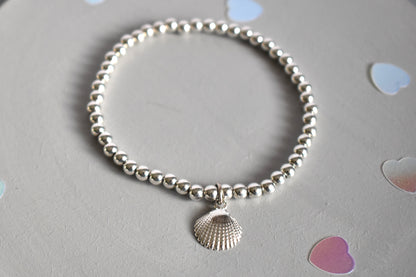 Sterling silver beaded bracelets with 4mm beads. Suspended from the bracelet  is a sterling silver clamshell. From the Ocean Collection of stacking bracelets.