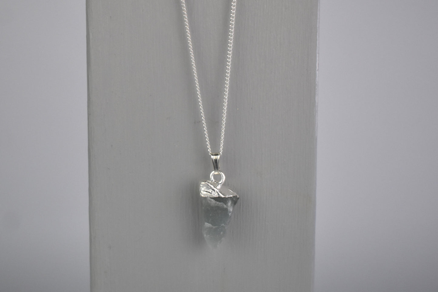 raw crystal moonstone shown with sterling silver tip and suspended sterling silver chain