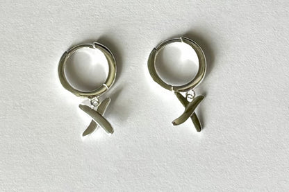 Huggie earrings to match our golden kisses necklace. 9mm  huggies shown in sterling silver have a "kiss" dangling from each earring.