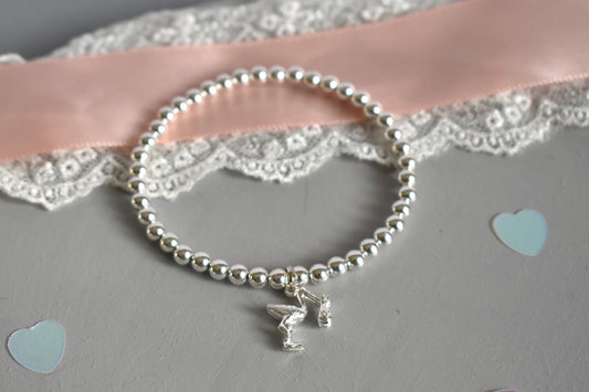 4mm sterling silver beads are threaded onto strong elastic from which is suspended a sterling silver stork carrying a little bundle. The perfect bracelet for new mums.