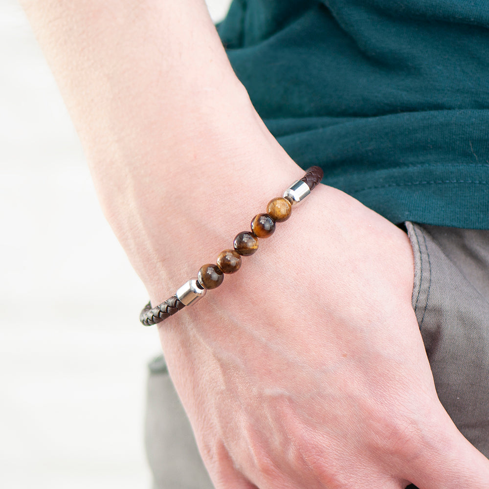 Shown worn. Brown woven leather bracelet with five tiger's eye beads. Barrel clasp engraved with initials and your own message