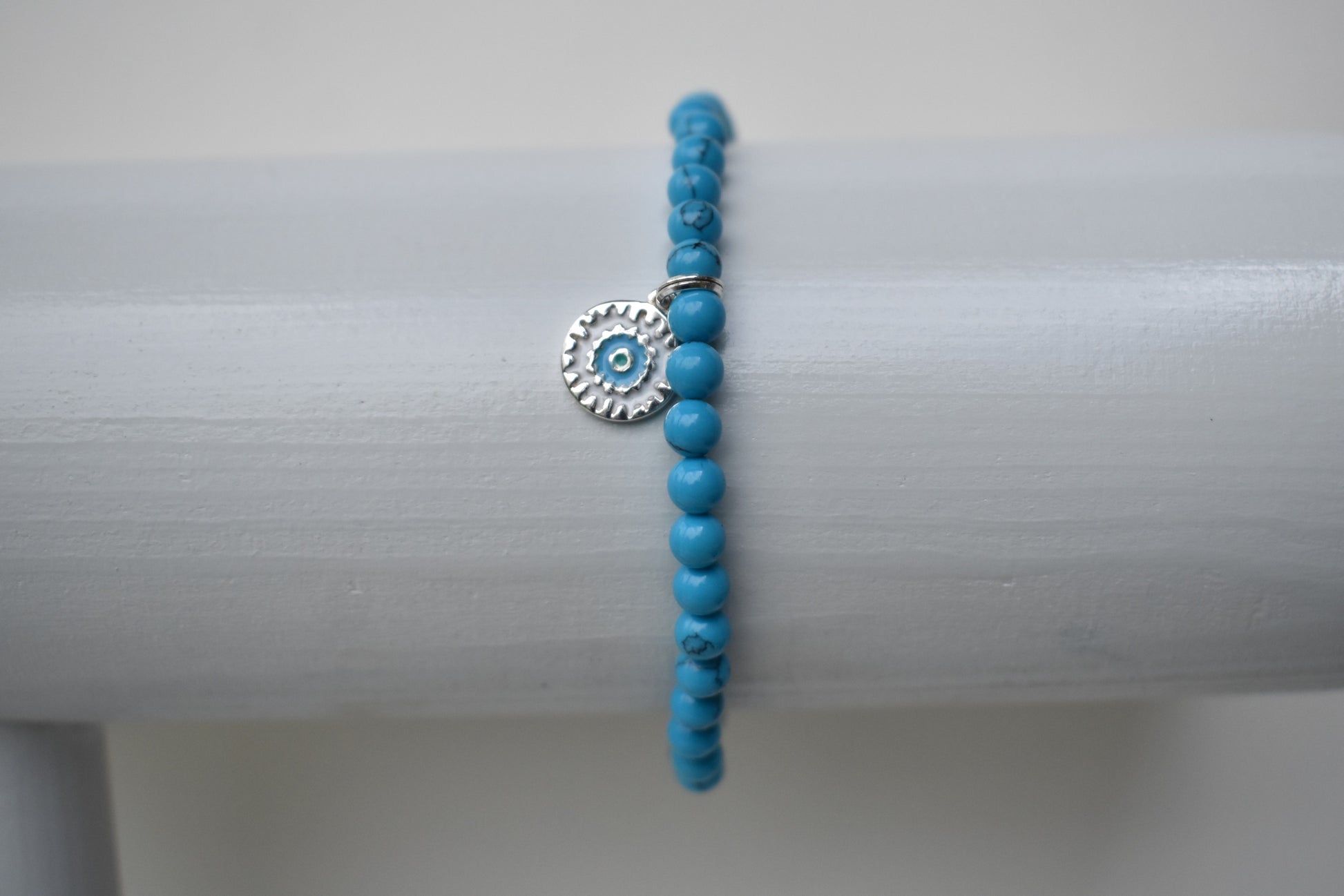 Elasticated bracelet with 4mm reconstituted turquoise beads and a perfect sterling silver mandala charm, make the perfect beach bracelet.