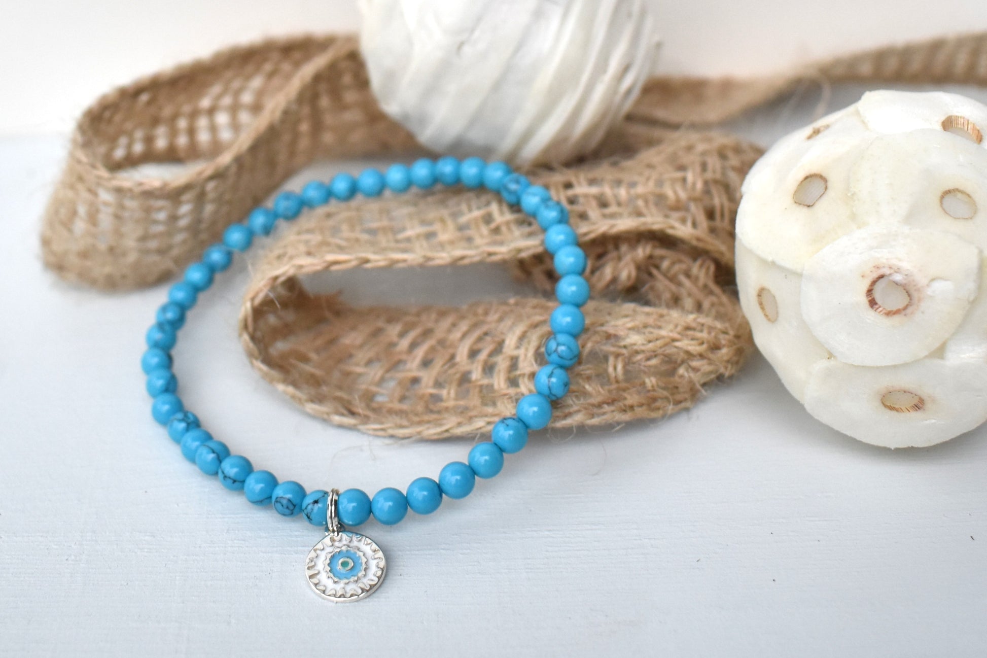 Elasticated bracelet with 4mm reconstituted turquoise beads and a perfect sterling silver mandala charm, make the perfect beach bracelet.