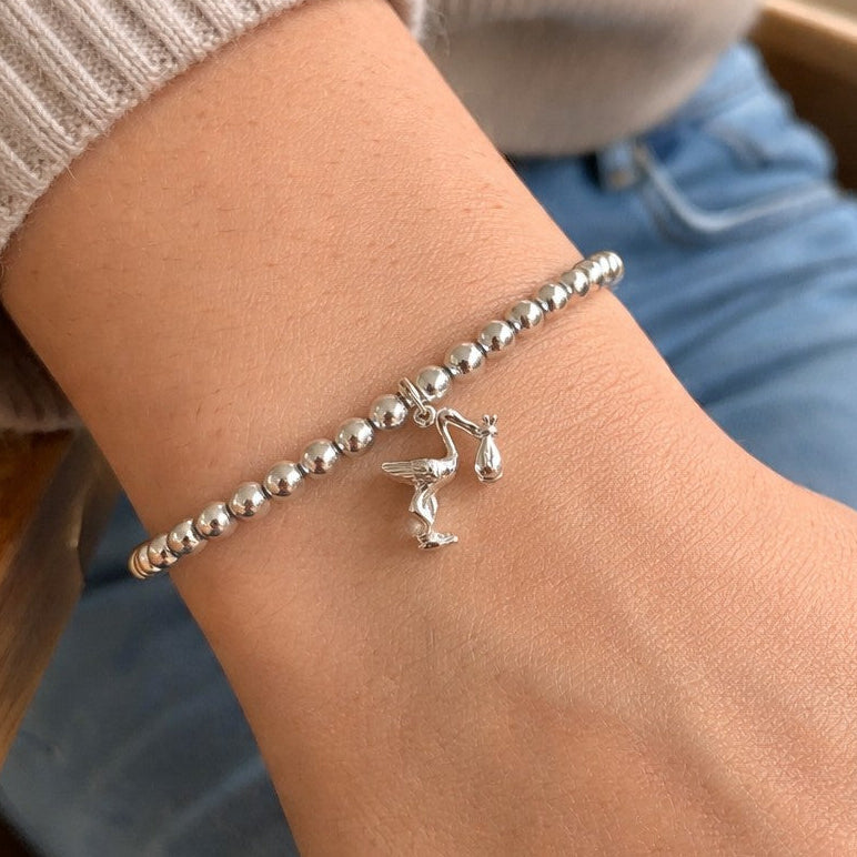 4mm sterling silver beads are threaded onto strong elastic from which is suspended a sterling silver stork carrying a little bundle. The perfect bracelet for new mums.