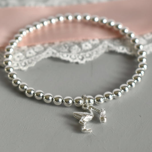 4mm sterling silver beads are threaded onto strong elastic from which is suspended a sterling silver stork carrying a little bundle. The perfect bracelet for new mums.