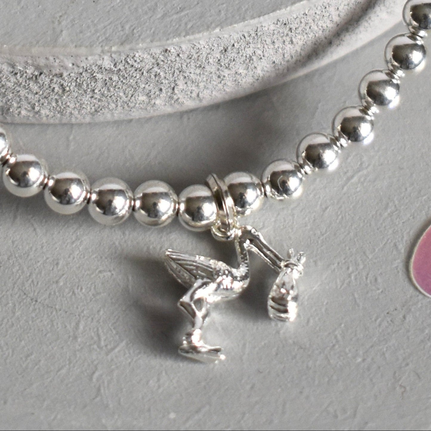 4mm sterling silver beads are threaded onto strong elastic from which is suspended a sterling silver stork carrying a little bundle. The perfect bracelet for new mums.