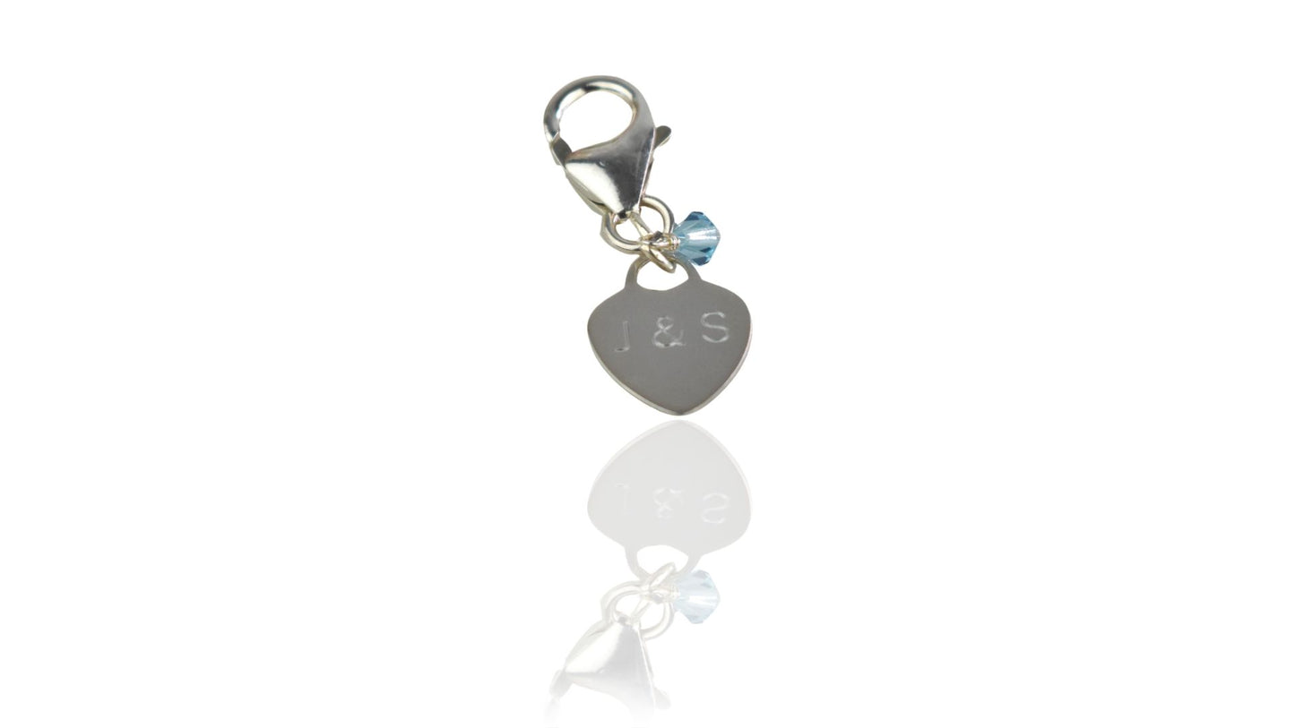 sterling silver engraved heart with couples' initials or  numerical wedding date. Tiny blue crystal. Lobster pin means it can be fastened to a bouquet or a shoe