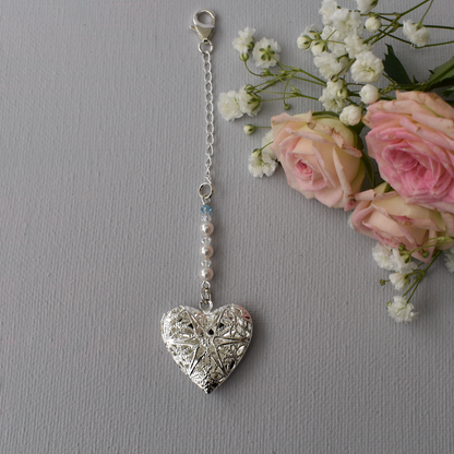 A pretty silver filigree locket is suspended from a row of high quality glass pearls and crystals and finished with a tiny something blue bead. A chain and lobster clasp makes it easy to fasten to your wedding bouquet