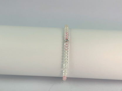 glass beads in clear with a touch of pink form this elasticated bracelet