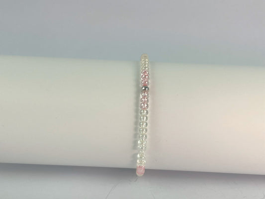 glass beads in clear with a touch of pink form this elasticated bracelet