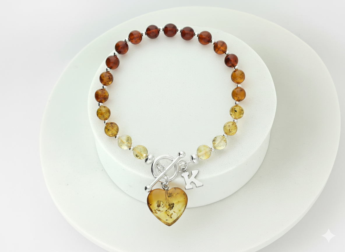 Cognac amber bracelet fastened with sterling silver TBar clasp and dangling heart charm shown with optional initial in sterling silver