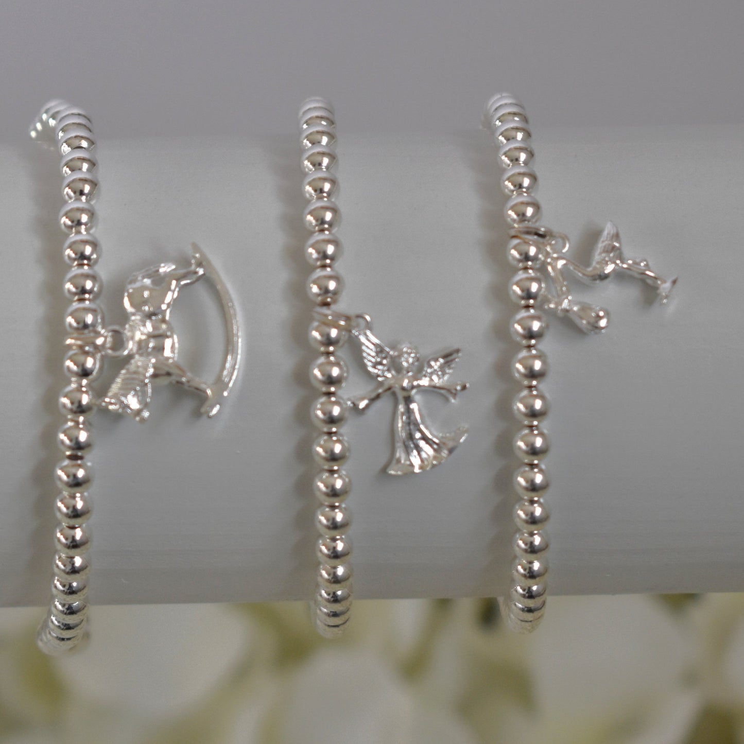 Three silver beaded bracelets - rocking horse, fairy angel and stork