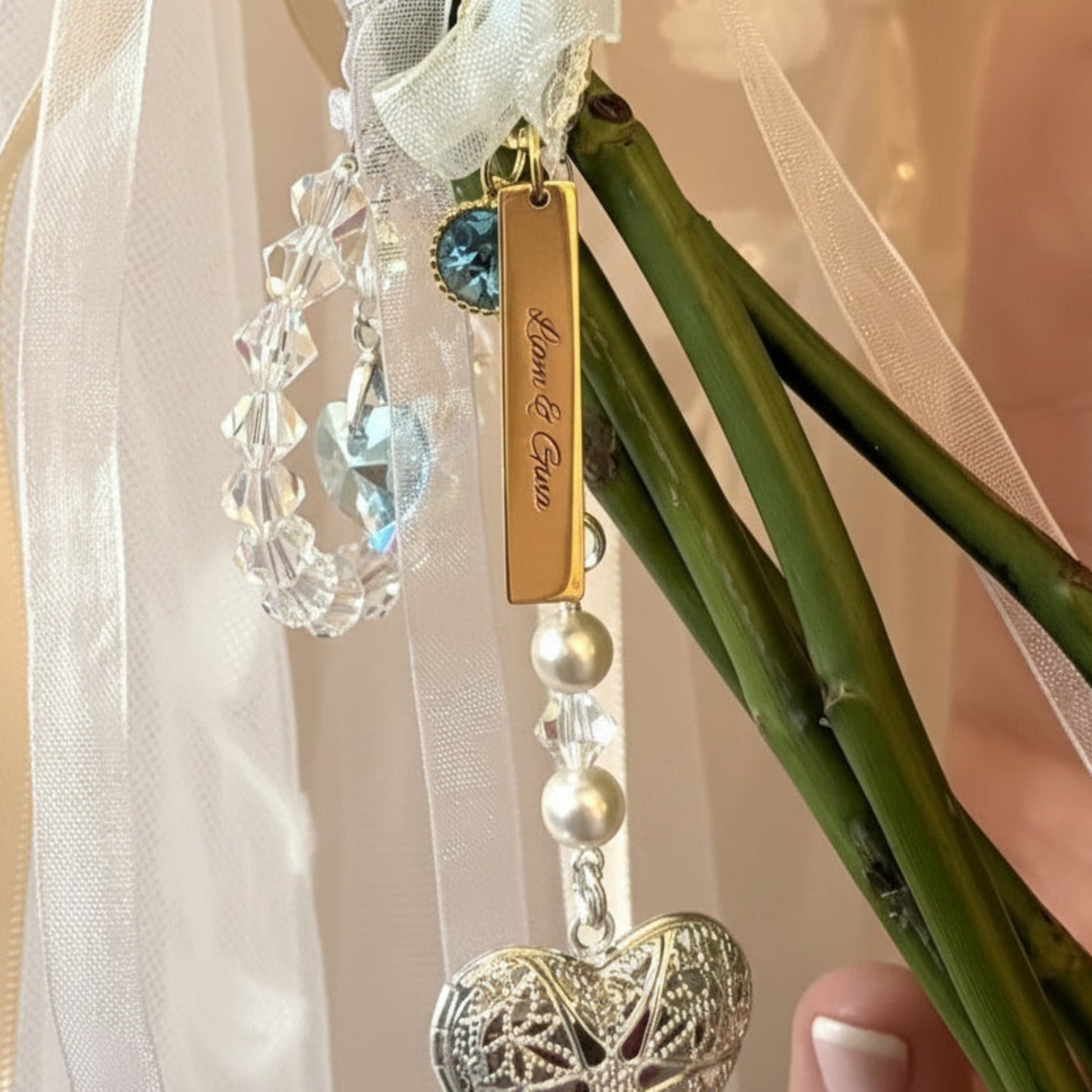 A circle of blue crystals surround a blue crystal heart - shown on a customer's bouquet