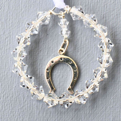 A circle of sparkling Austrian crystals surrounds a sterling silver horseshoe charm. Finished with white ribbon to be fastened to wedding bouquet