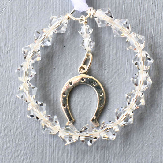 A circle of sparkling Austrian crystals surrounds a sterling silver horseshoe charm. Finished with white ribbon to be fastened to wedding bouquet
