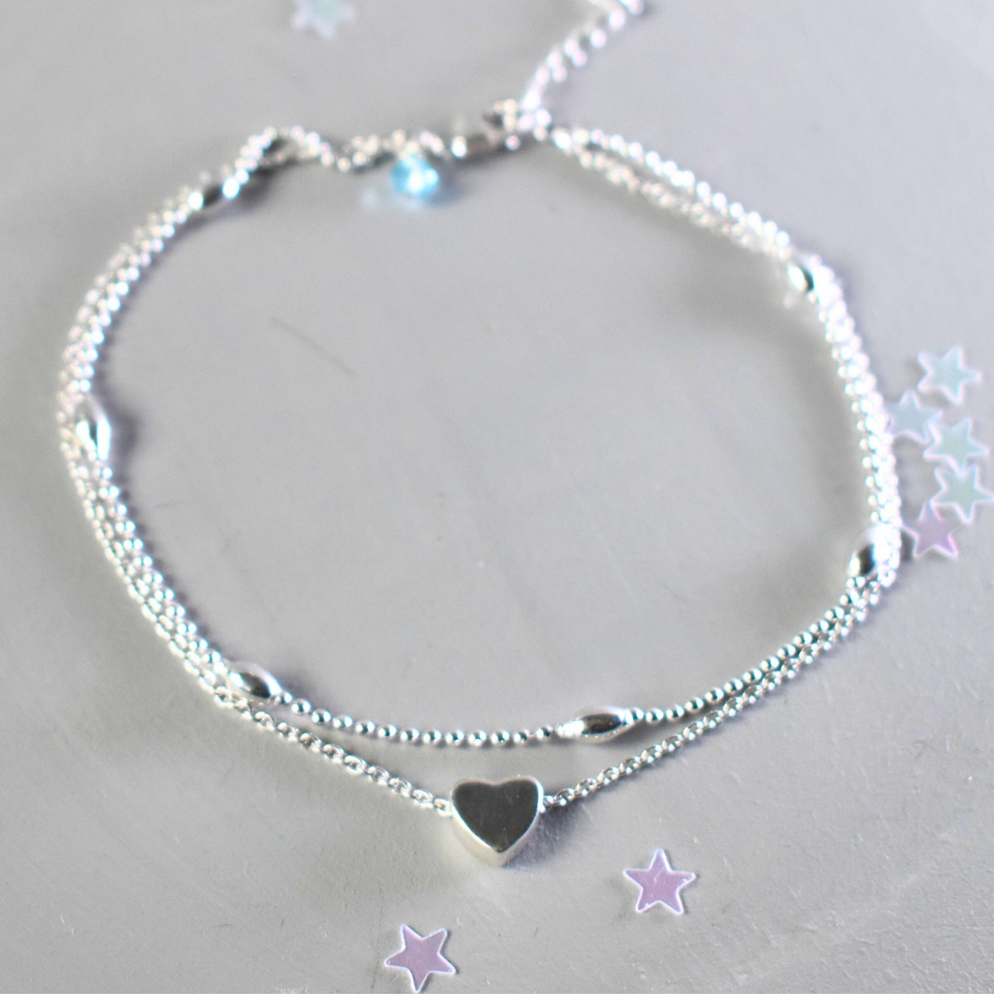sterling silver double strand beaded anklet with heart centre. Added near the fastening is an optional tiny blue crystal to serve as a bride's "something blue"