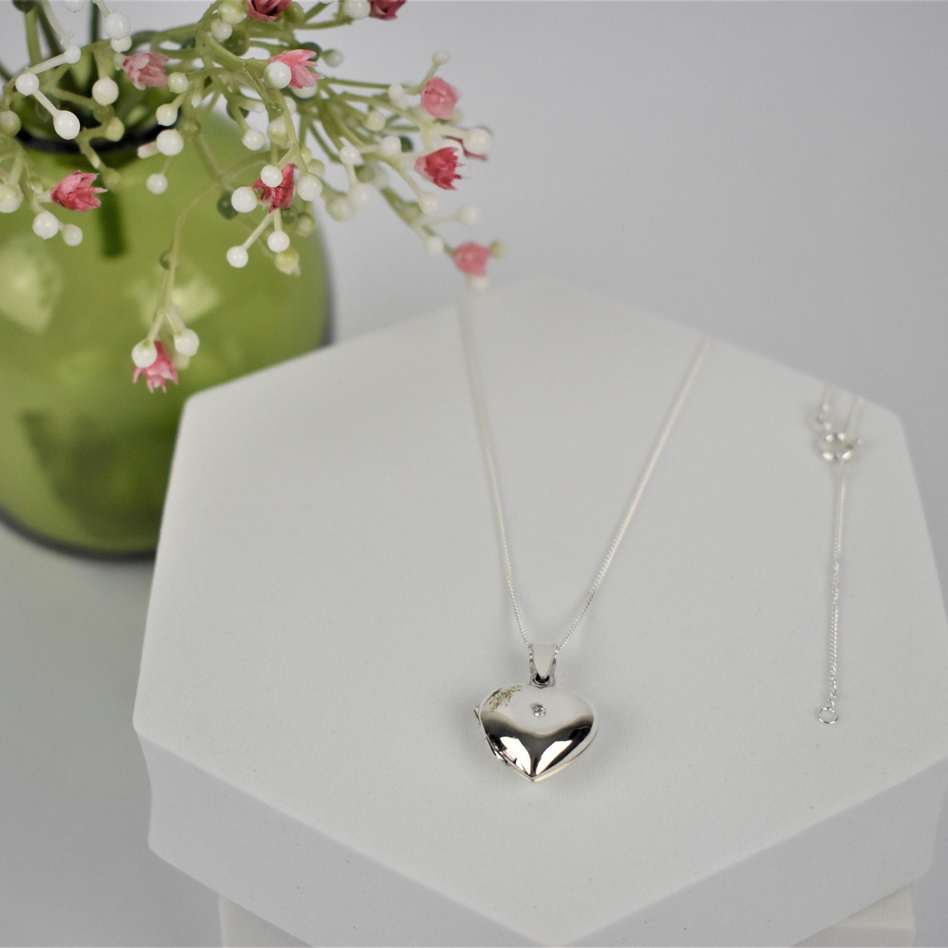 Silver heart-shaped opening locket necklace with a cubic zirconia stone in the centre