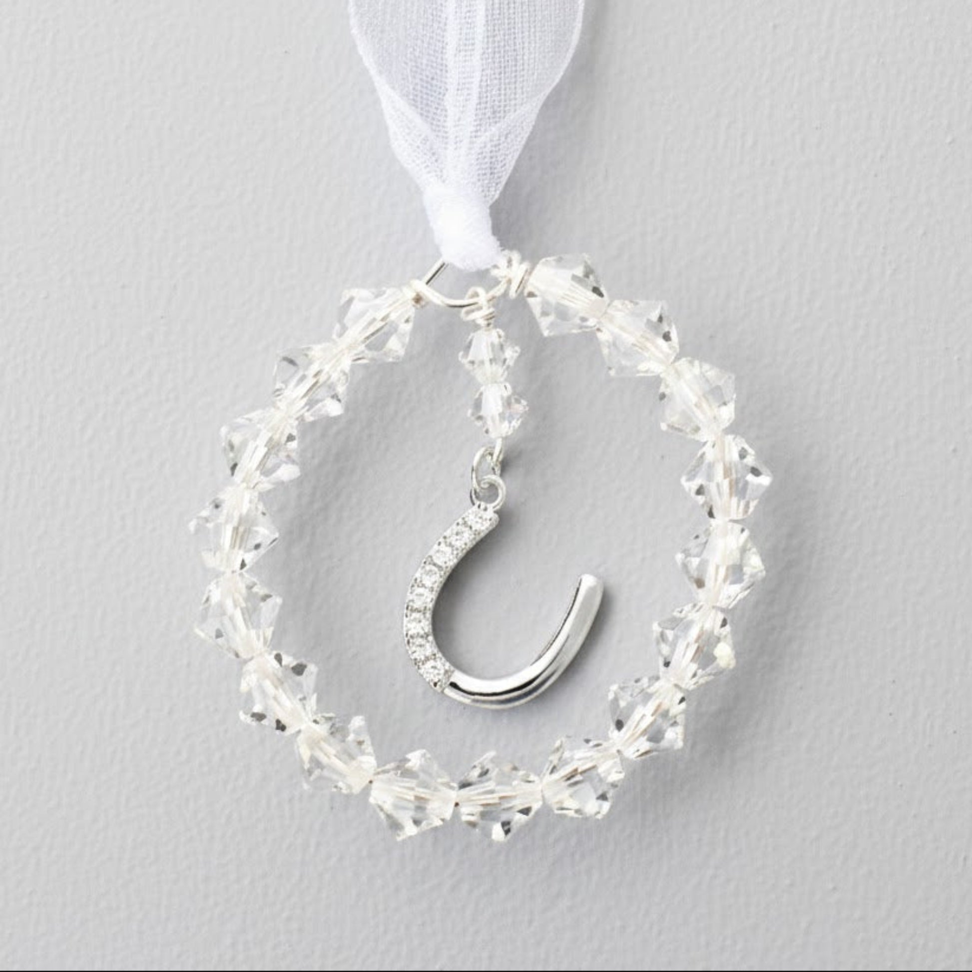 A circle of crystals surrounds a sterling silver horseshoe studded with tiny zircona. The perfect bouquet charm. The horsehoe is detachable for use as a pendant after the event. 
