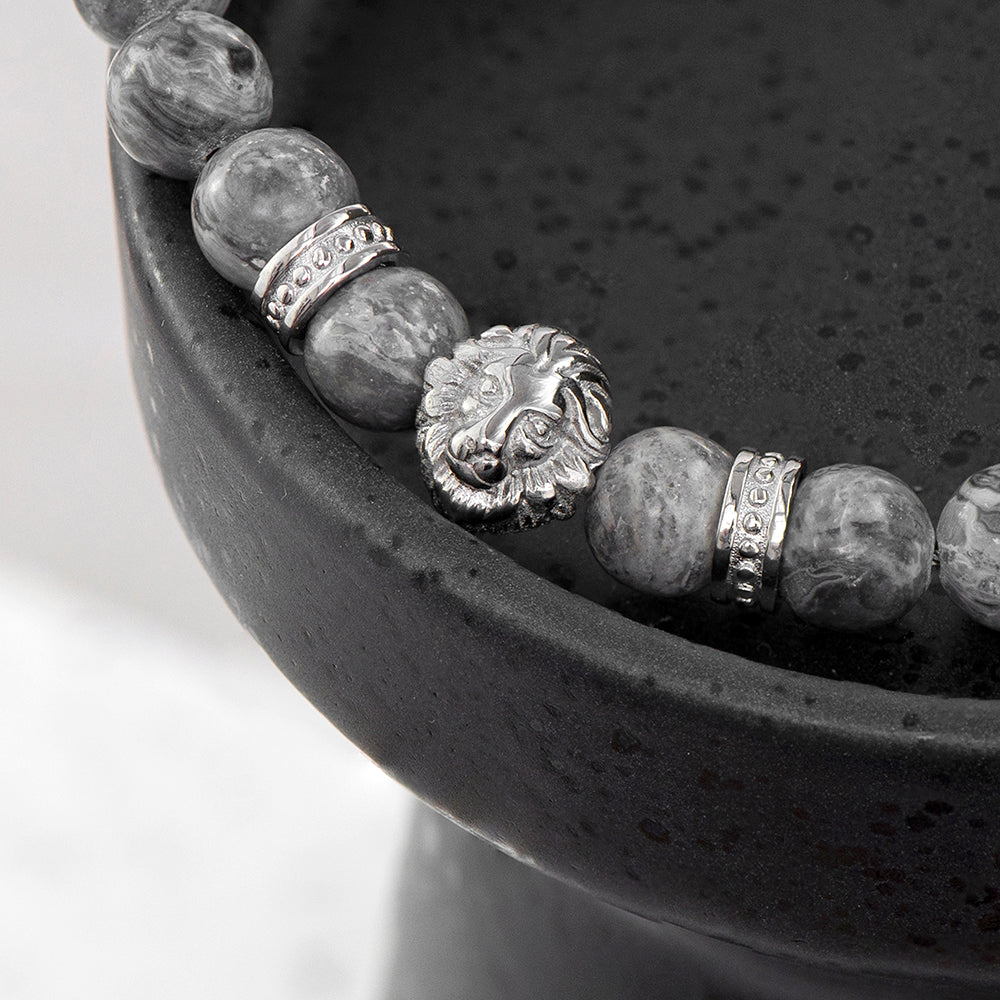 Grey jasper beads with a central lion's head in stainless steel. The barrel clasp can be engraved with up to three initials and a message of up to 15 charactes includingspaces. Arrives gift boxed. Lions head and bead close up