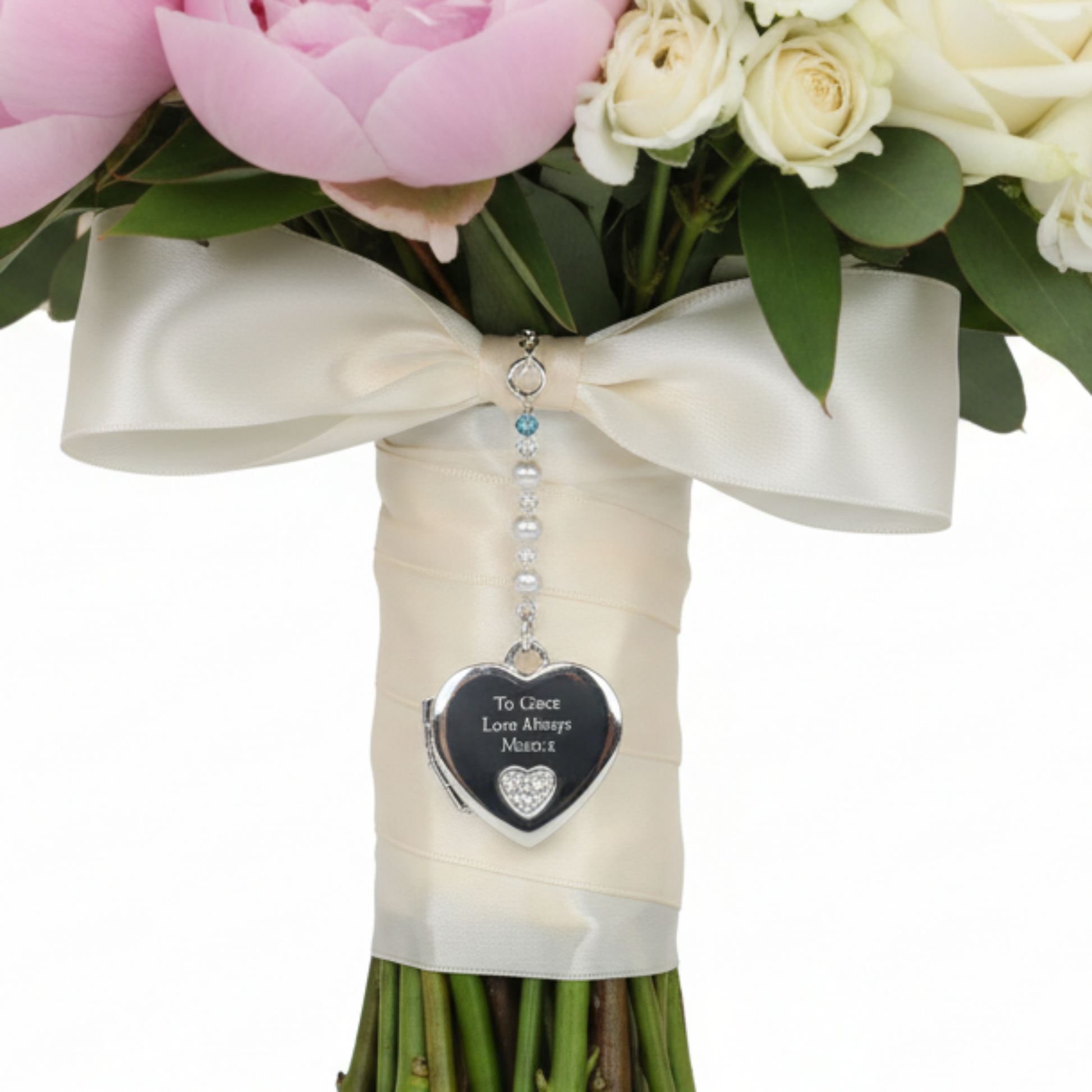 Sterling silver heart shaped locket wedding bouquet charm. Shown on wedding bouquet. Suspended from a string of crystals and glass pearls with a tiny something blue bead