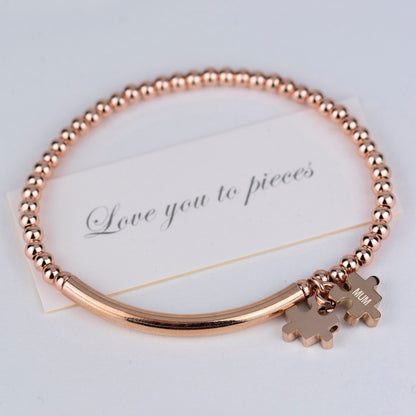 Love you to pieces bead and bar bracelet shown in rose gold, with one jigsaw charm engraved Mum, and accompanying love you to pieces card