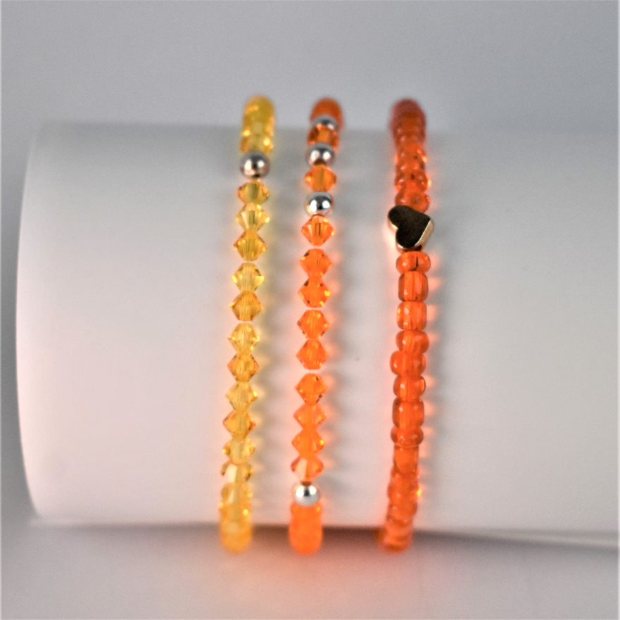 the fiery orange beaded bracelet is teamed with one orange and one yellow crystal bracelet to form the perfect stack