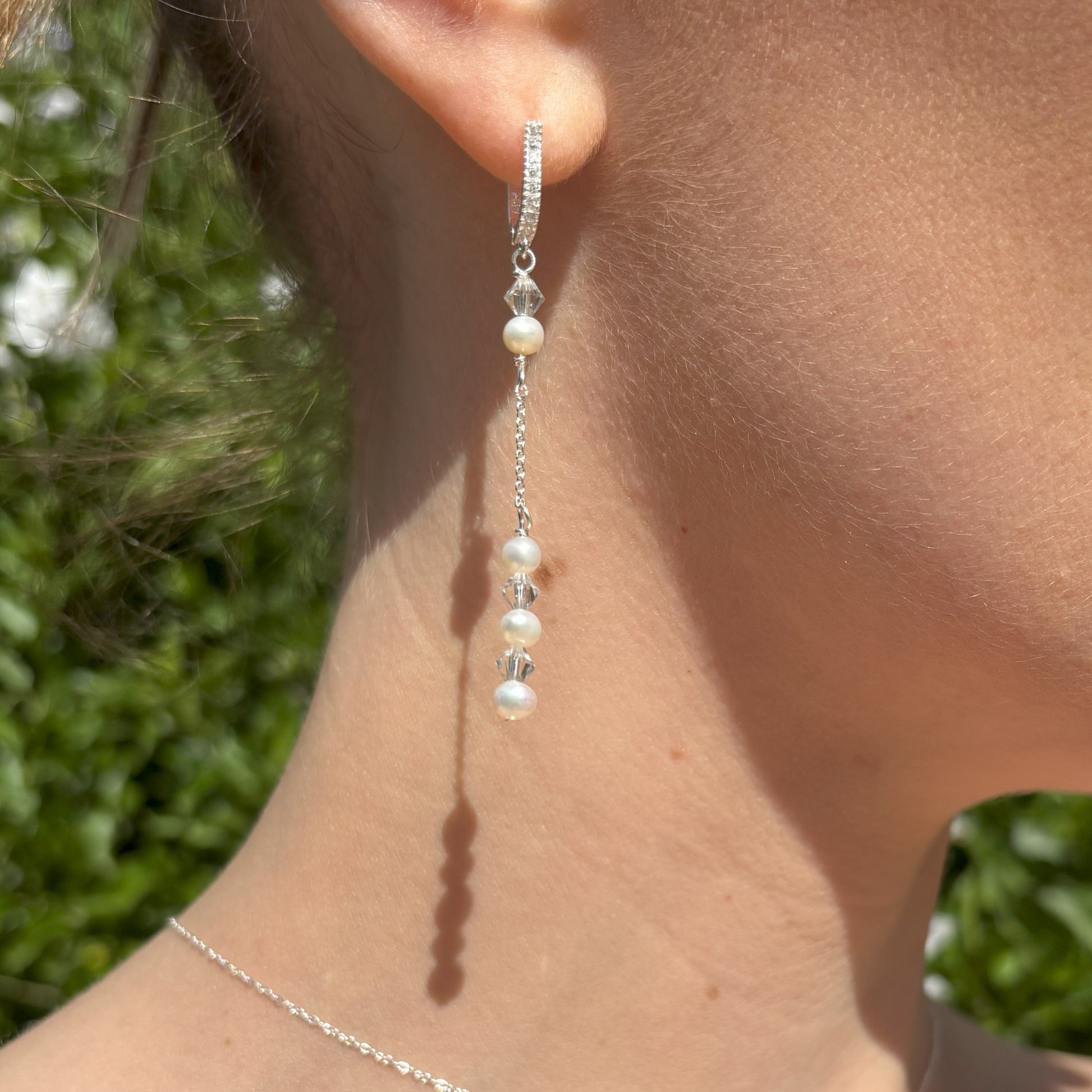 Pearl and crystal earrings using 4mm freshwater pearls and highest quality crystals (also 4mm). The earrings are suspended from sterling silver hoops studded with tiny crystals to reflect the light. Shown worn with our pearl back drop necklace. 