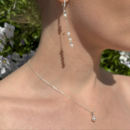 Pearl and crystal earrings using 4mm freshwater pearls and highest quality crystals (also 4mm). The earrings are suspended from sterling silver hoops studded with tiny crystals to reflect the light. Shown worn with our pearl back drop necklace. 