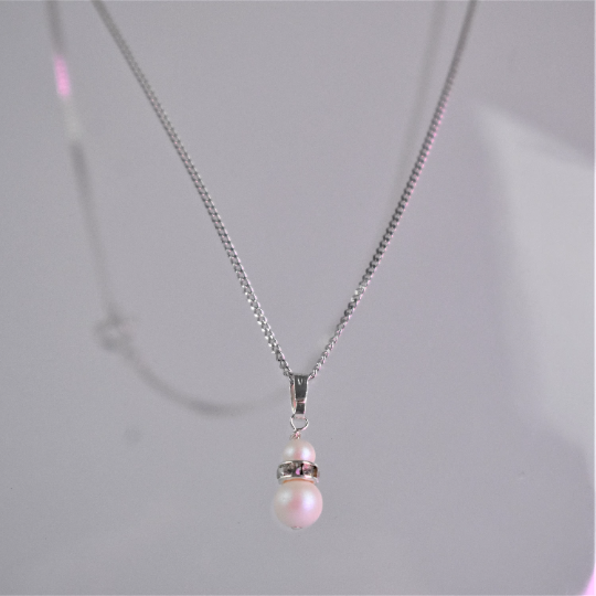 close up of double pearl pendant