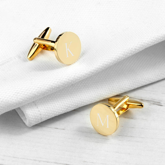 Gold plated circular cufflinks shown with one initial on each link.