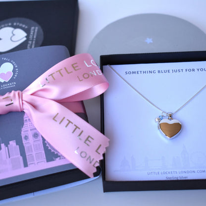Heart-shaped necklace with gold heart detail on a card, accompanied by a pink ribbon with 'Little Lockets London' text.


