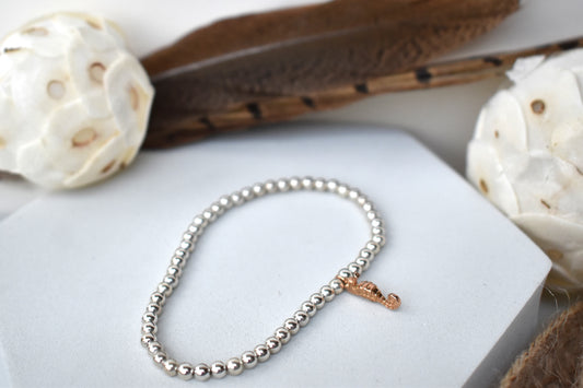 silver plated 4mm beads form an elasticated bracelet. A gold vermeil seahorse completes the look.
