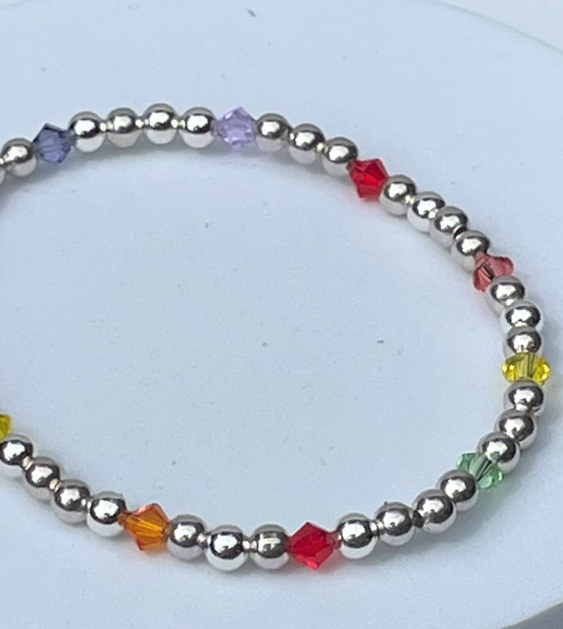 Elasticated silver plated beaded bracelet interspersed with rainbow colour crystals. 