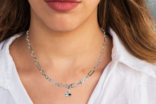 Model wears Sterling silver necklace of linked infinity symbols hung with birthstones of your choice