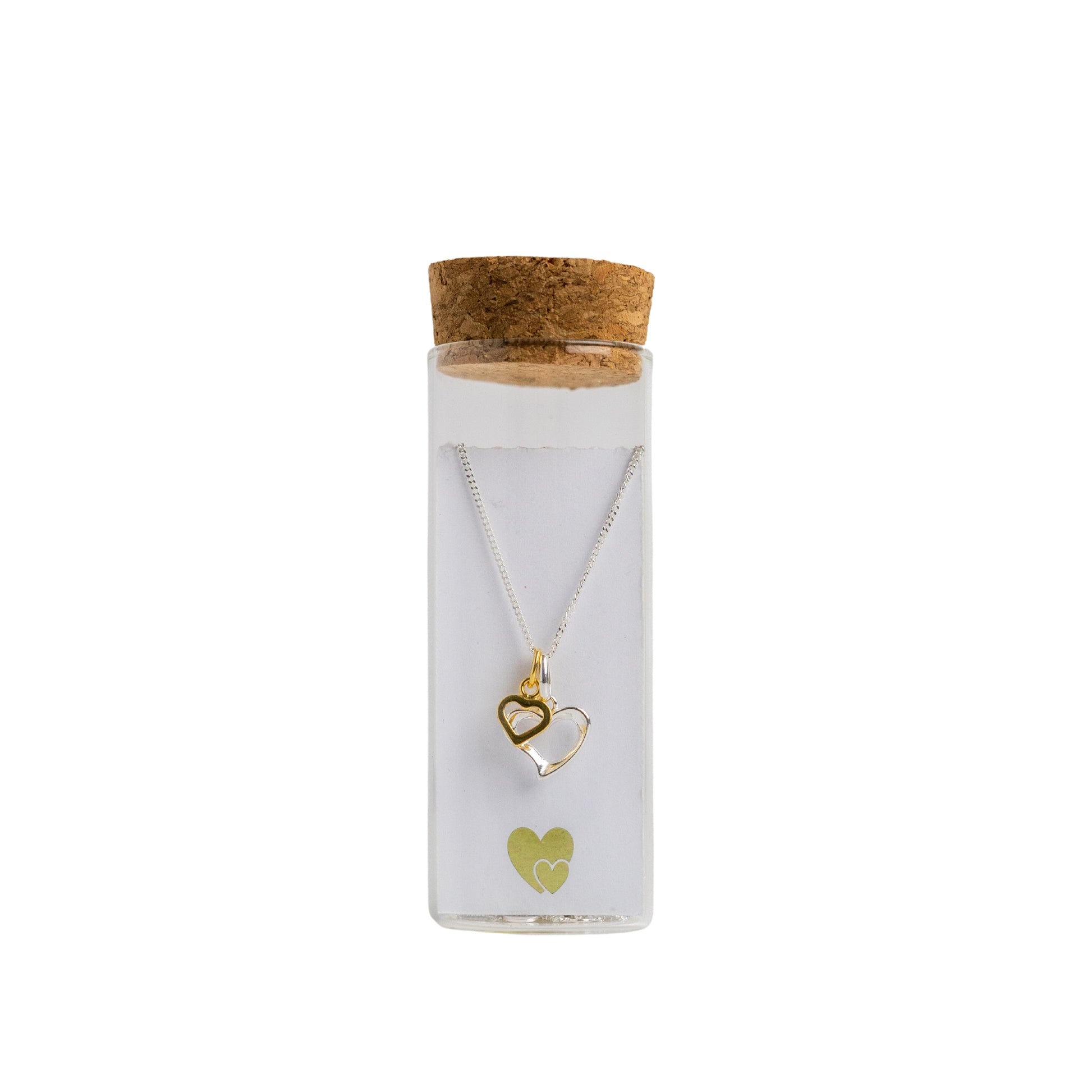 Message in a Bottle jewellery. A sterling silver heart is twinned with a smaller gold vermeil heart and suspended from a 16-18" sterling silver chain. The necklace is placed in a small glass bottle that includes a scroll personalised with a message of your choice.